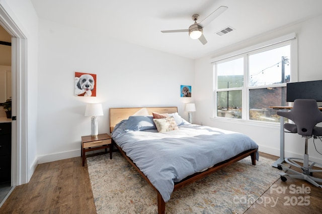 55 S Market St Unit 101, Asheville, NC 28801 - bedroom with visible vents, baseboards, a ceiling fan, and wood finished floors
