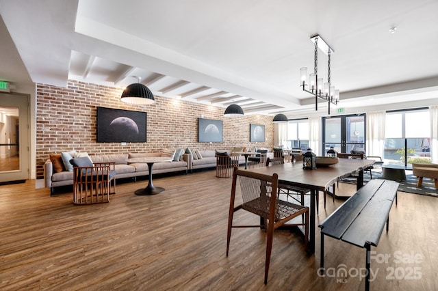 55 S Market St Unit 101, Asheville, NC 28801 - dining space featuring beamed ceiling, wood finished floors, brick wall, and a healthy amount of sunlight