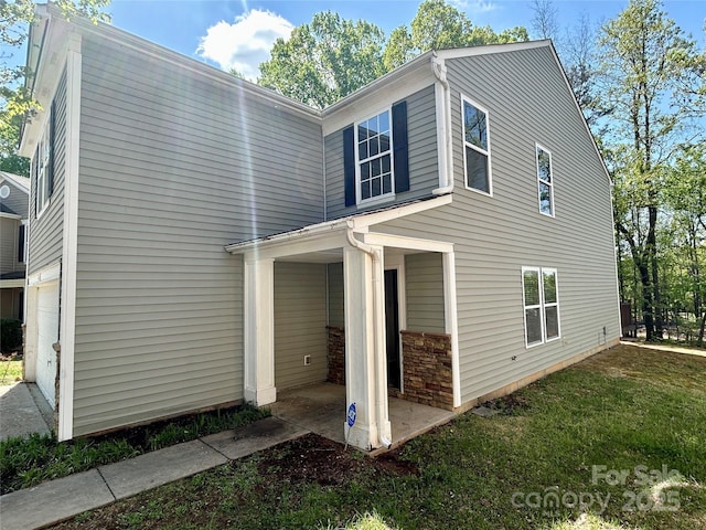 2752 Bramble Ridge Ct, Charlotte, NC 28215 - view of home's exterior featuring a garage, a patio, and a lawn