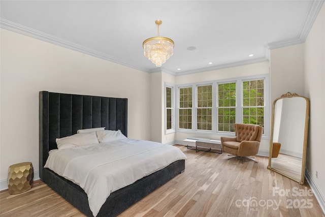 bedroom featuring an inviting chandelier, ornamental molding, baseboards, and light wood-style floors