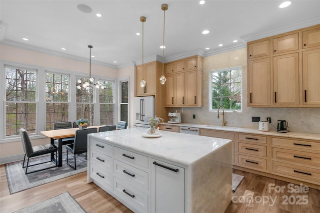 kitchen with light wood-type flooring, ornamental molding, light brown cabinetry, a sink, and high end white refrigerator