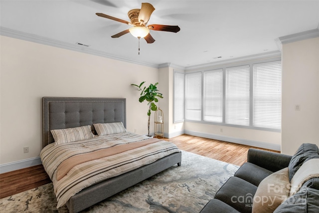 bedroom with baseboards, wood finished floors, and ornamental molding