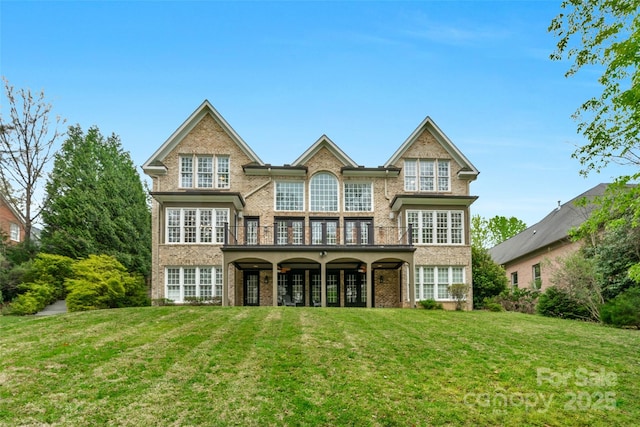 back of house featuring brick siding and a lawn