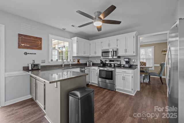 2439 Heathershire Ln, Matthews, NC 28105 - kitchen with appliances with stainless steel finishes, a sink, a peninsula, and white cabinets
