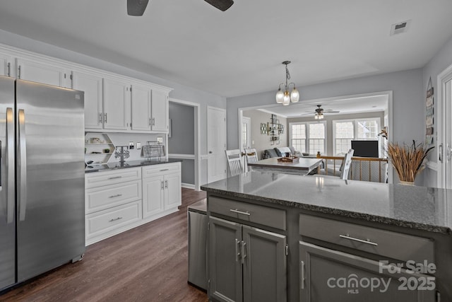 2439 Heathershire Ln, Matthews, NC 28105 - kitchen with stainless steel fridge, a ceiling fan, dark stone countertops, and white cabinetry