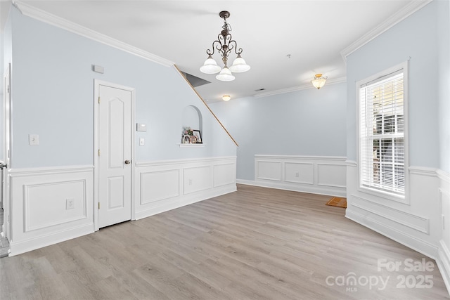1386 21st Ave NE, Hickory, NC 28601 - unfurnished dining area featuring ornamental molding, a chandelier, a wainscoted wall, light wood-style flooring, and a decorative wall