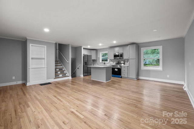 1801 Weststone Dr, Charlotte, NC 28208 - kitchen featuring light wood-style flooring, light countertops, appliances with stainless steel finishes, and a kitchen island