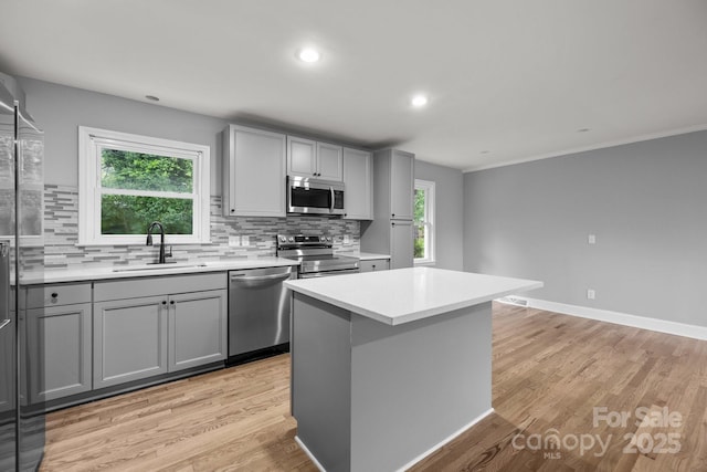 1801 Weststone Dr, Charlotte, NC 28208 - kitchen featuring tasteful backsplash, gray cabinetry, light wood-style floors, appliances with stainless steel finishes, and a sink