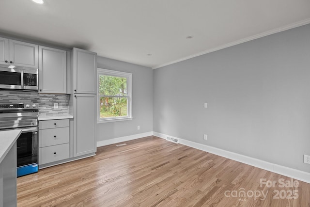 1801 Weststone Dr, Charlotte, NC 28208 - kitchen with light wood-style flooring, light countertops, baseboards, and stainless steel appliances