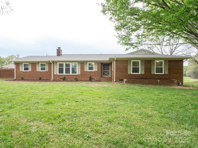 ranch-style house featuring a chimney, brick siding, and a front yard