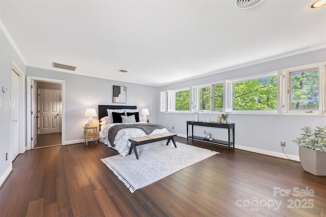 bedroom featuring dark wood-type flooring, visible vents, baseboards, and ornamental molding