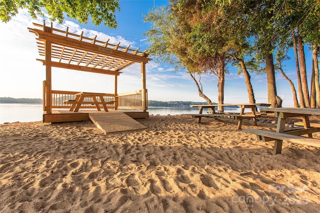 surrounding community featuring a pergola and a water view