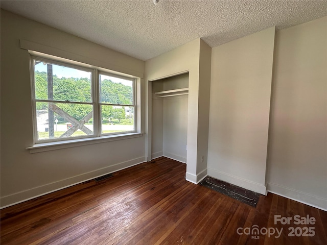31 Hildebrand St Unit 1 & 154, Asheville, NC 28801 - unfurnished bedroom featuring a closet, a textured ceiling, wood-type flooring, baseboards, and visible vents