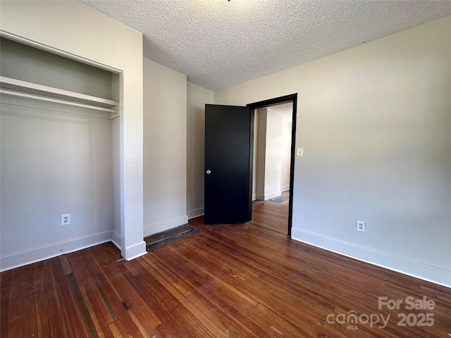 31 Hildebrand St Unit 1 & 154, Asheville, NC 28801 - unfurnished bedroom with baseboards, a closet, a textured ceiling, and wood-type flooring