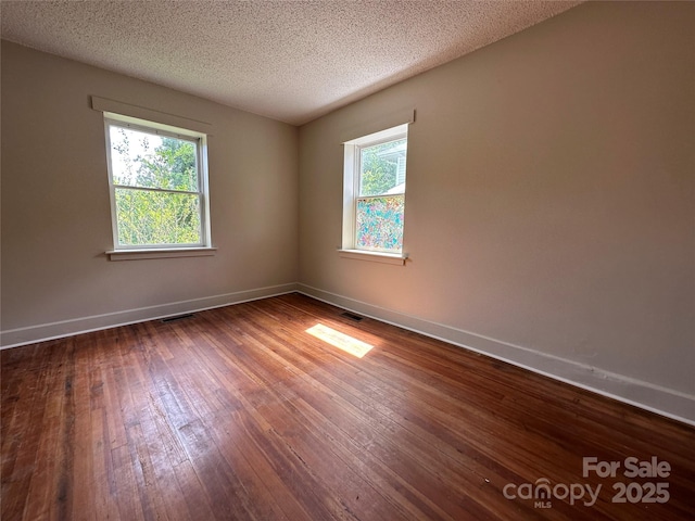 31 Hildebrand St Unit 1 & 154, Asheville, NC 28801 - spare room featuring visible vents, dark wood-type flooring, baseboards, and a textured ceiling