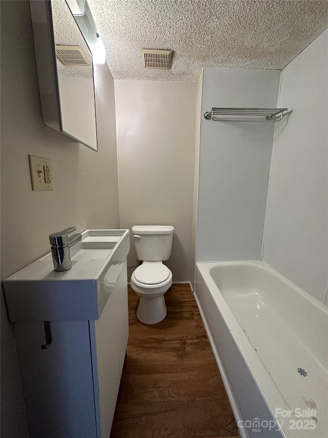 31 Hildebrand St Unit 1 & 154, Asheville, NC 28801 - full bathroom featuring vanity, toilet, a textured ceiling, visible vents, and wood finished floors