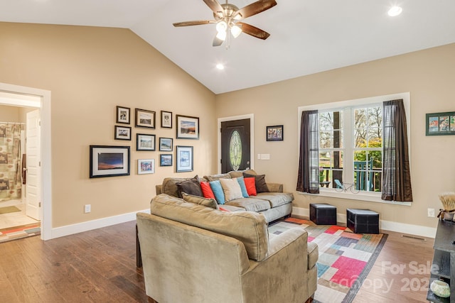 living area featuring baseboards, lofted ceiling, ceiling fan, and wood finished floors