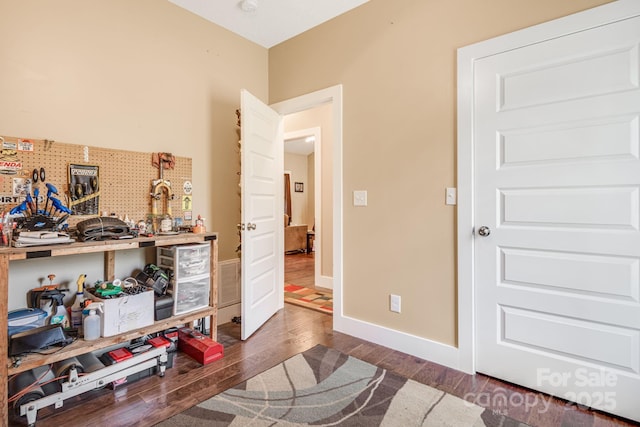 interior space with dark wood-type flooring, visible vents, and baseboards
