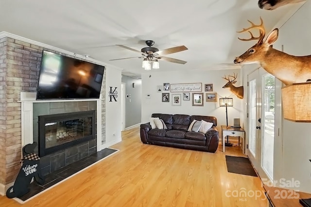 110 Tanglewood Dr, Kannapolis, NC 28081 - living area with baseboards, a tiled fireplace, a ceiling fan, crown molding, and wood finished floors