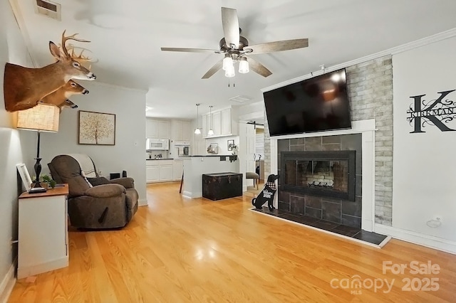 110 Tanglewood Dr, Kannapolis, NC 28081 - living area featuring light wood-type flooring, ceiling fan, a fireplace, and visible vents