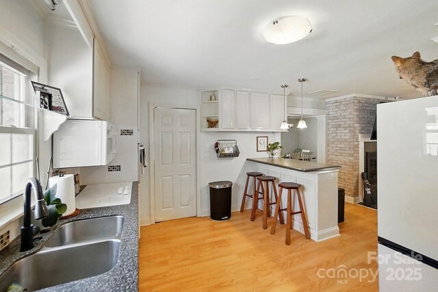 110 Tanglewood Dr, Kannapolis, NC 28081 - kitchen featuring white appliances, a peninsula, open shelves, a sink, and a breakfast bar area