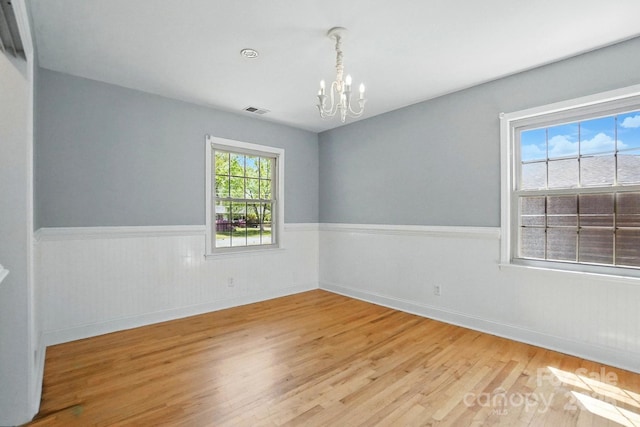 110 Tanglewood Dr, Kannapolis, NC 28081 - empty room with visible vents, a wainscoted wall, wood finished floors, baseboards, and a notable chandelier