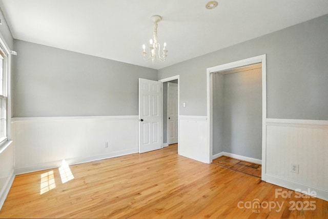 110 Tanglewood Dr, Kannapolis, NC 28081 - unfurnished bedroom with a chandelier, wood finished floors, a closet, and a wainscoted wall