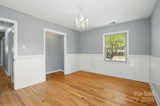 110 Tanglewood Dr, Kannapolis, NC 28081 - spare room with visible vents, a wainscoted wall, an inviting chandelier, and light wood-style floors