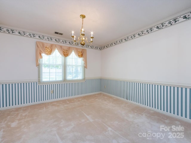 carpeted spare room featuring wallpapered walls, a notable chandelier, visible vents, and a wainscoted wall