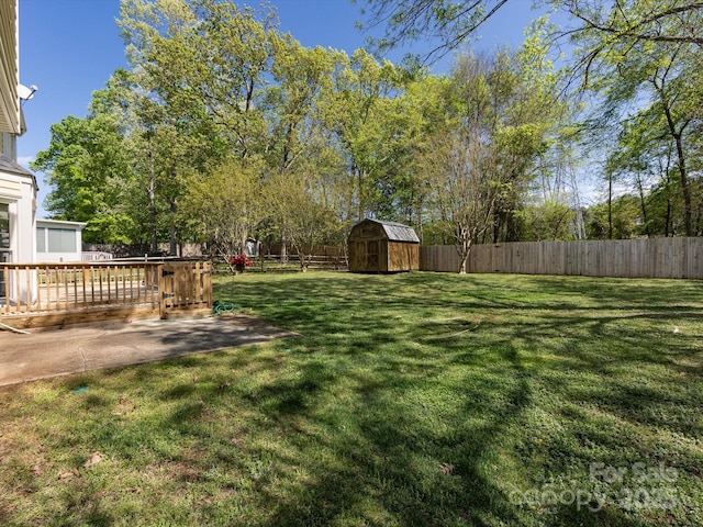 view of yard featuring a patio area, a fenced backyard, an outdoor structure, and a shed