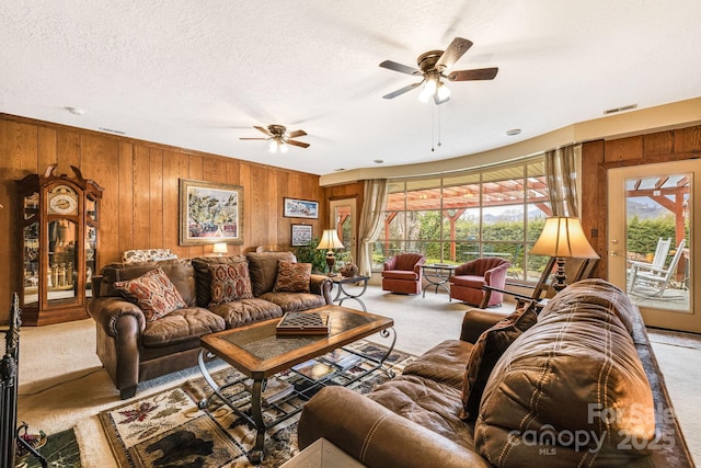 142 Country Club Dr, Waynesville, NC 28786 - carpeted living area featuring wooden walls, a healthy amount of sunlight, a ceiling fan, and visible vents