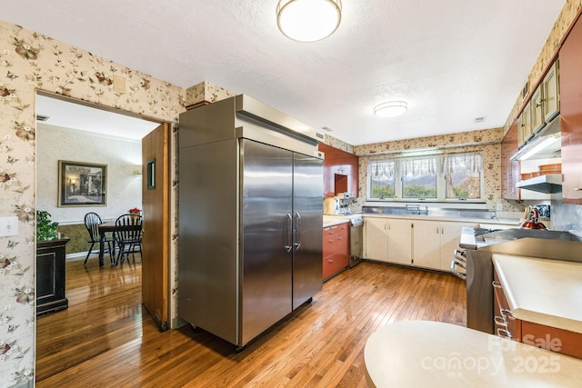 142 Country Club Dr, Waynesville, NC 28786 - kitchen with light countertops, wallpapered walls, light wood-style floors, and appliances with stainless steel finishes