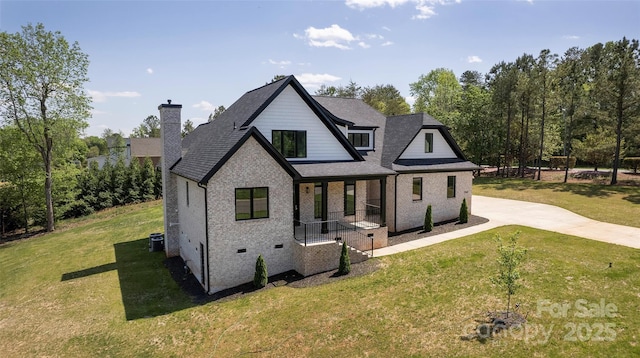 rear view of property featuring a yard, roof with shingles, and central AC