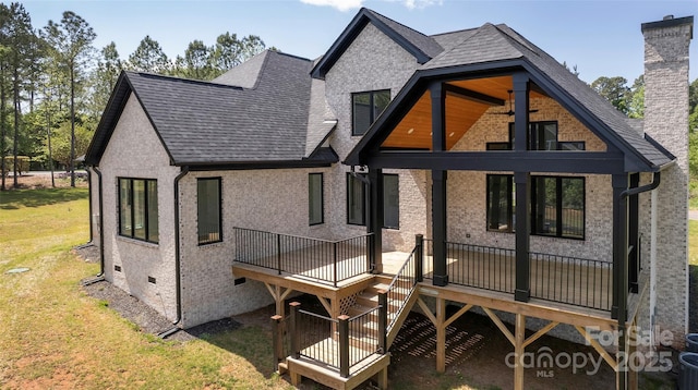 rear view of property with a yard, crawl space, a chimney, a wooden deck, and roof with shingles
