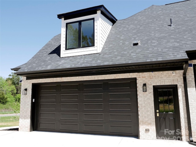 exterior space with concrete driveway and roof with shingles