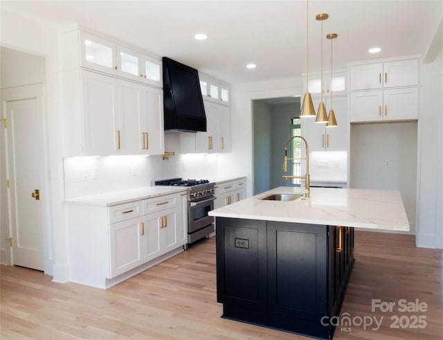 kitchen featuring a sink, white cabinets, stainless steel stove, and extractor fan