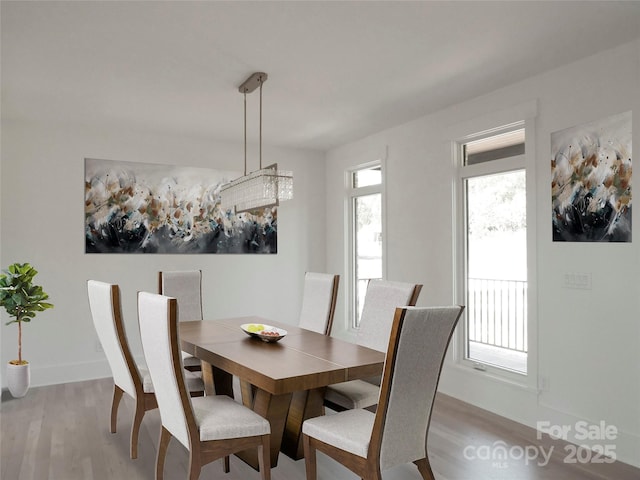 dining area featuring light wood-style floors and baseboards