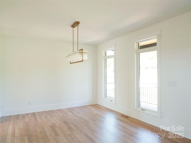 unfurnished dining area with light wood finished floors, baseboards, and visible vents