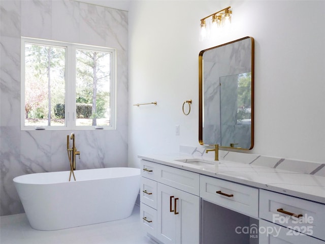 full bathroom featuring a freestanding bath, vanity, and a wealth of natural light