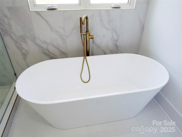 interior details with a baseboard radiator and a freestanding tub