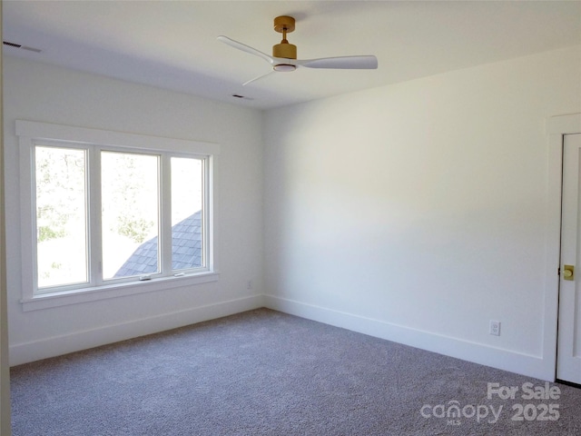 carpeted spare room featuring visible vents, baseboards, and a ceiling fan
