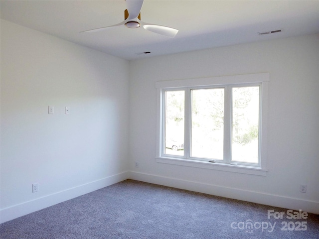 carpeted empty room with visible vents, baseboards, and a ceiling fan