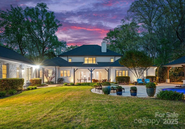 200 Highland Forest Dr, Charlotte, NC 28270 - back of property at dusk with a patio, an outdoor living space, a chimney, and a yard
