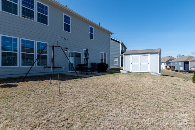 2097 Saddlebred Dr, Iron Station, NC 28080 - rear view of property with a storage shed, a patio area, an outbuilding, and a yard