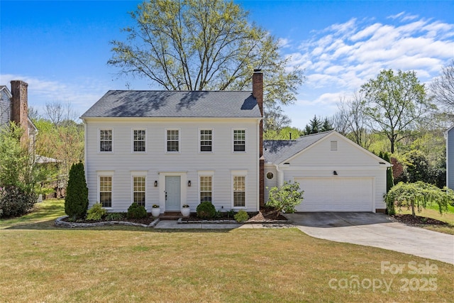 colonial house with driveway, a front yard, a garage, and a chimney