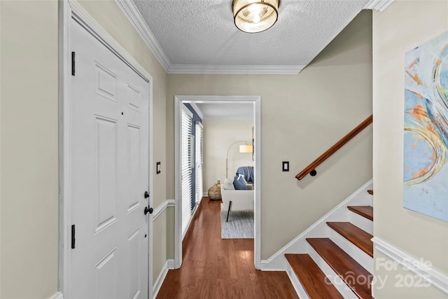 entryway with stairway, ornamental molding, baseboards, a textured ceiling, and dark wood-style floors