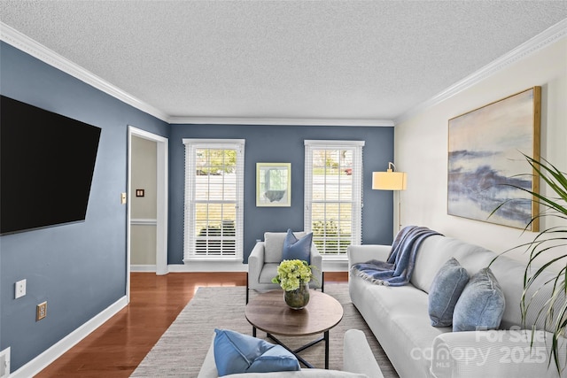 living area with ornamental molding, a textured ceiling, baseboards, and wood finished floors