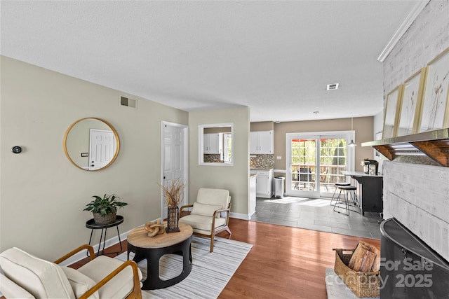 living area featuring dark wood-style flooring, baseboards, and visible vents