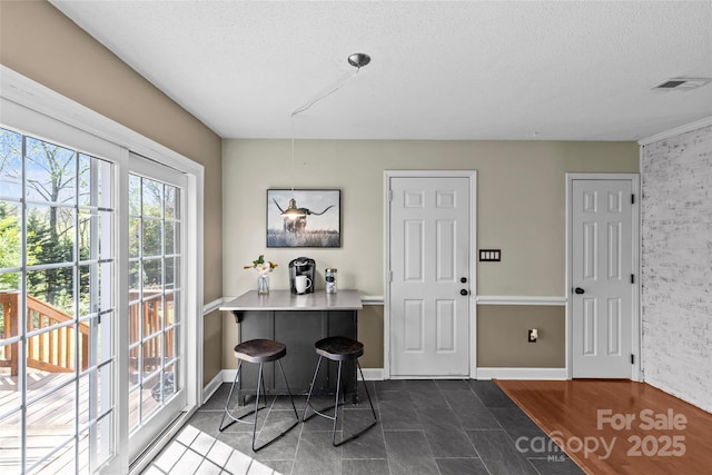 interior space with baseboards, visible vents, dark wood-type flooring, and a textured ceiling