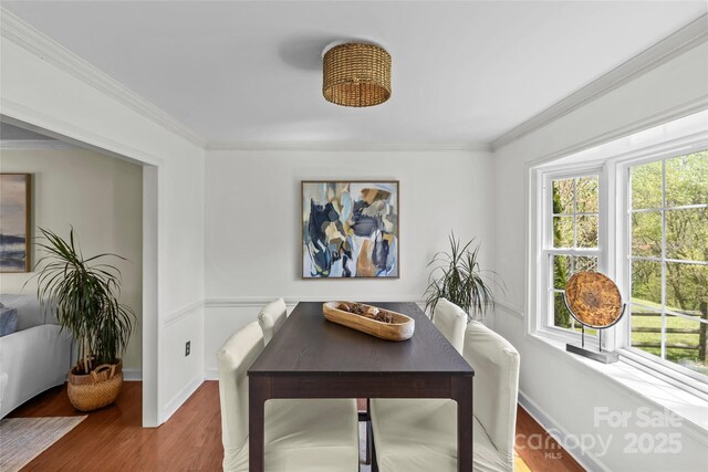 dining area with ornamental molding, baseboards, and wood finished floors